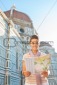 Happy young woman with map in front of cattedrale di santa maria