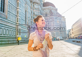 Happy young woman with map in front of cattedrale di santa maria