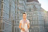 Young woman standing with map in front of cattedrale di santa ma
