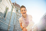 Portrait of smiling young woman with map in front of cattedrale 