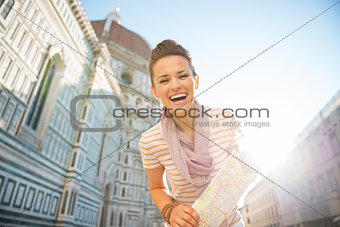 Portrait of smiling young woman with map in front of cattedrale 