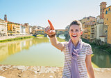 Happy young woman standing on bridge overlooking ponte vecchio i