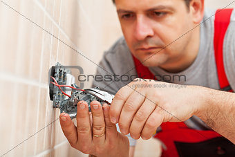 Electrician working on electrical wall fixture