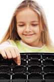 Little girl planting putting seeds into germination tray