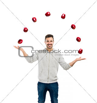 Happy man juggling with apples 