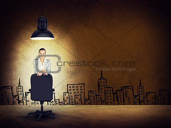 Woman wearing jacket, blouse leaning on chair. Background sketch of buildings