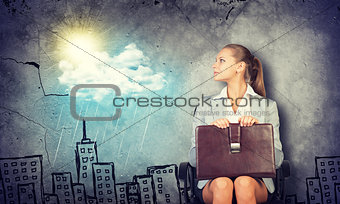 Woman in jacket holding briefcase and looking at camera. Background sketch of houses, sun, rain, cloud