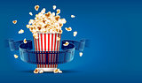 Popcorn for cinema and movie film tape on blue background