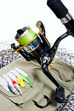 Fishing rod and lures on white.