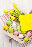 Easter with yellow tulips, colorful eggs and gift bag