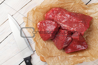 Raw fillet beef steak pieces and kitchen knife