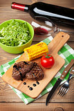 Steak with grilled corn, salad and red wine
