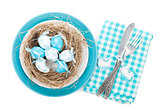 Easter eggs nest on plate with silverware
