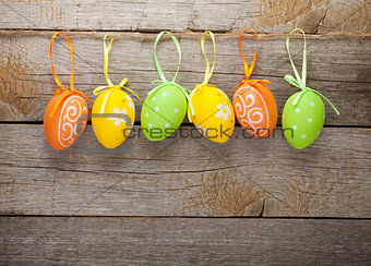 Easter eggs nest on plate over wooden background
