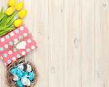 Easter background with blue and white eggs in nest, yellow tulip