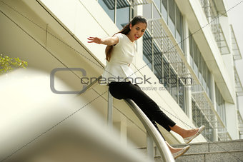 Cheerful Business Woman Going Downstairs Sliding On Rail For Joy