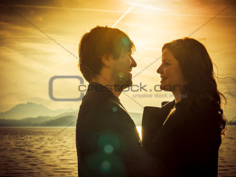 Couple standing by the lake in the sunlight