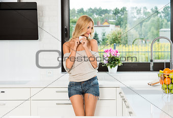 informal girl , drinking coffee in kitchen