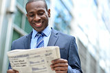 Handsome african man reading a newspaper