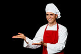 Smiling male chef presenting something