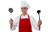 Male chef holding kitchen essentials