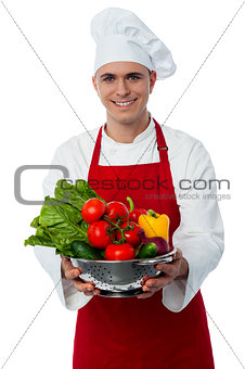 Smiling male chef with fresh vegetables