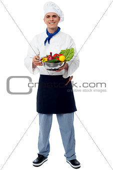 Smiling chef with fresh vegetables