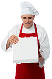 Young male chef holding pizza box