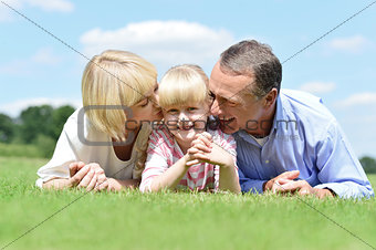 Smiling couple with daughter posing at outdoors
