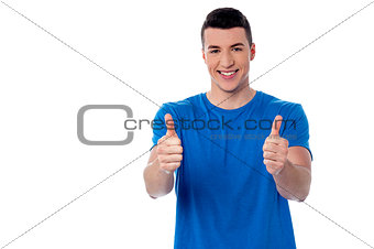 Young smiling man showing thumbs up
