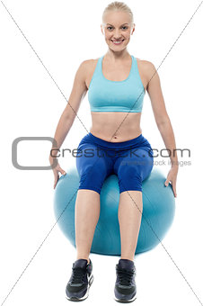 Sporty woman exercising with blue ball