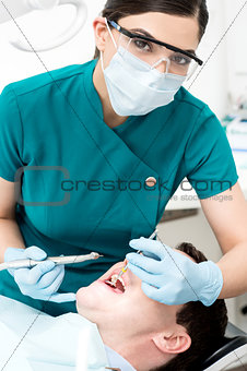 Female dentist examines a patient