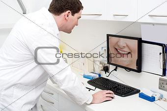 Dentist using computer in dental clinic