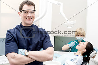 Assistant treating carious teeth of patient