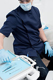 Male dentist with tools at dental clinic