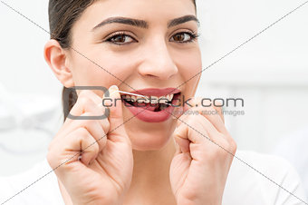 Woman cleaning teeth with floss
