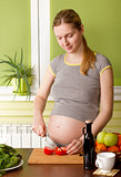 Pregnant woman on kitchen cooking