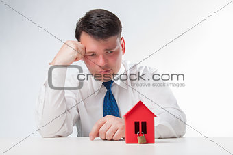 Sad Man with a red paper house