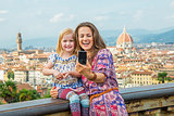 Happy mother and baby girl making selfie against panoramic view 