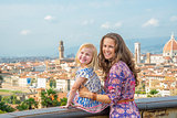 Portrait of happy mother and baby girl against panoramic view of