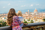 Mother and baby girl looking on panoramic view of florence, ital