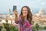 Happy young woman making selfie against panoramic view of floren