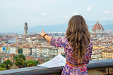 Young woman with map pointing on panoramic view of florence, ita