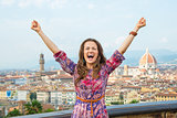 Happy young woman rejoicing against panoramic view of florence, 