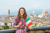 Happy young woman with flag against panoramic view of florence, 