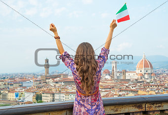 Young woman with flag rejoicing against panoramic view of floren