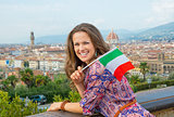 Happy young woman with flag against panoramic view of florence, 