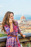 Happy young woman talking mobile phone against panoramic view of