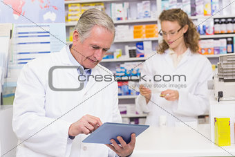 Senior pharmacist using tablet pc