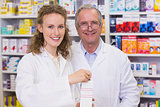 Pharmacists holding medicine looking at camera